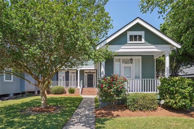 bungalow with a porch and a front lawn