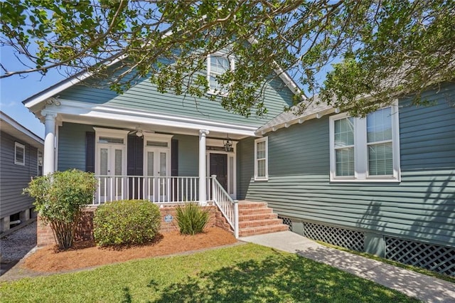 view of front of home with ceiling fan, a porch, and a front lawn