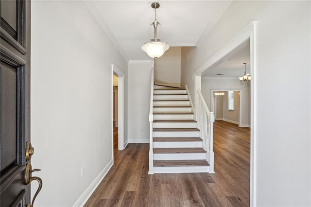 entrance foyer featuring crown molding, a notable chandelier, and dark hardwood / wood-style floors