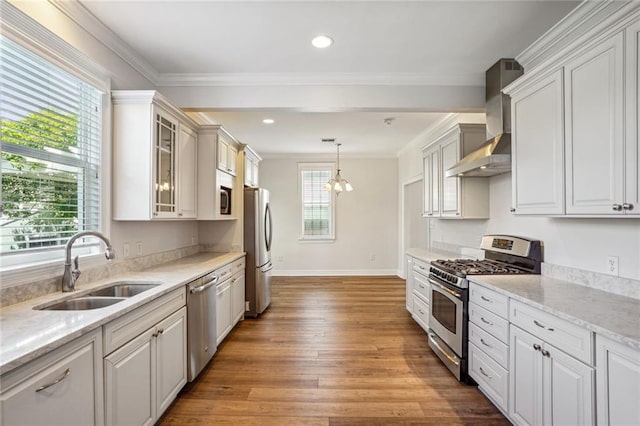 kitchen featuring hardwood / wood-style floors, white cabinetry, wall chimney range hood, and stainless steel appliances