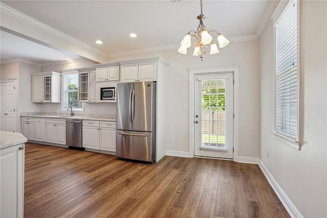 kitchen featuring appliances with stainless steel finishes, white cabinets, a healthy amount of sunlight, and wood-type flooring