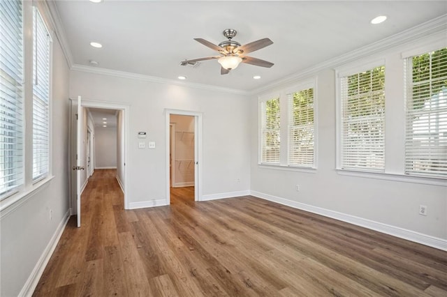 spare room with a wealth of natural light, ornamental molding, and wood-type flooring