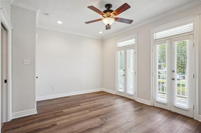 spare room featuring french doors, ornamental molding, dark wood-type flooring, and ceiling fan