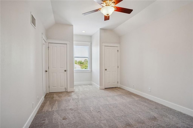 unfurnished bedroom featuring lofted ceiling, light colored carpet, and ceiling fan