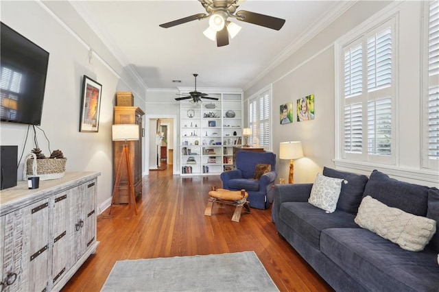 living room with ornamental molding, ceiling fan, and dark wood-type flooring