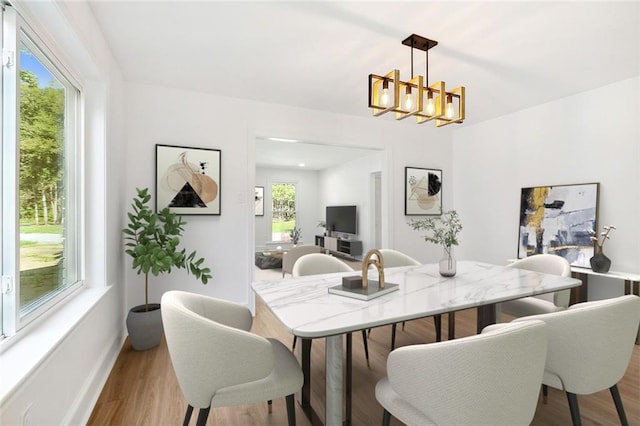 dining area featuring a notable chandelier and light hardwood / wood-style flooring