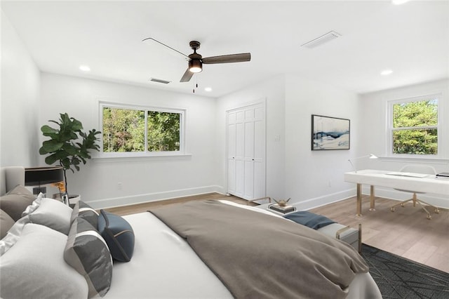 bedroom featuring multiple windows, ceiling fan, and hardwood / wood-style flooring