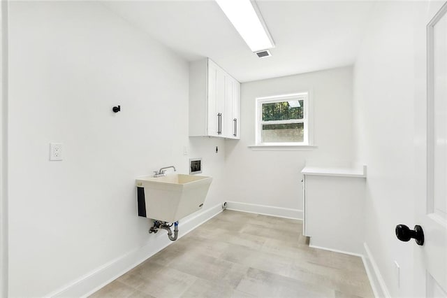 clothes washing area featuring hookup for a washing machine, hookup for an electric dryer, sink, and cabinets