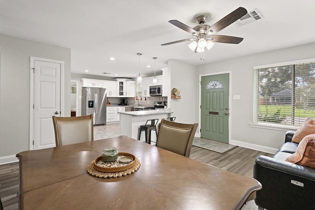 dining space featuring light hardwood / wood-style floors, sink, and ceiling fan