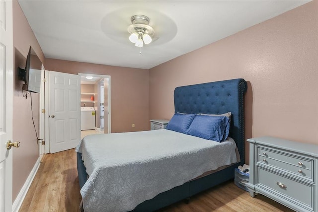 bedroom featuring washer / clothes dryer, light hardwood / wood-style floors, and ceiling fan