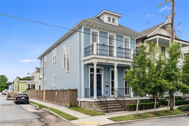 view of front of house with a balcony and covered porch