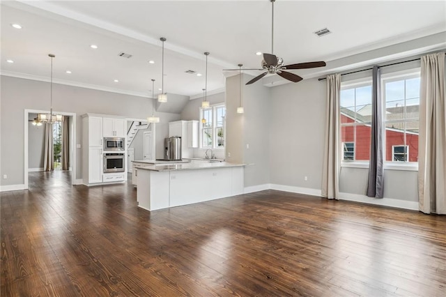 kitchen featuring appliances with stainless steel finishes, white cabinetry, ceiling fan with notable chandelier, decorative light fixtures, and dark hardwood / wood-style floors