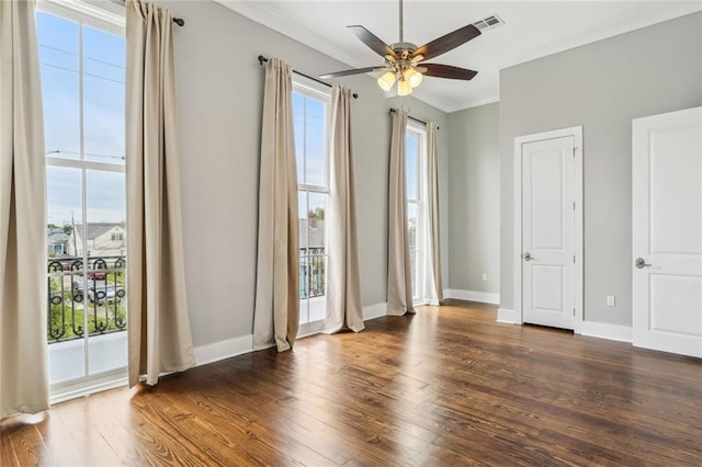 spare room with crown molding, ceiling fan, plenty of natural light, and dark hardwood / wood-style flooring