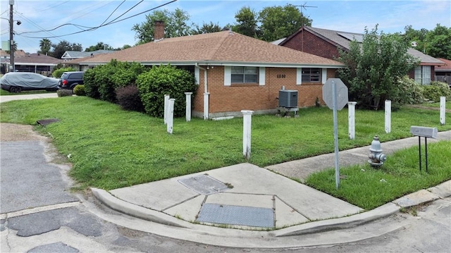 single story home featuring a front yard and central AC unit