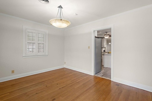 empty room with wood-type flooring, ceiling fan, and crown molding