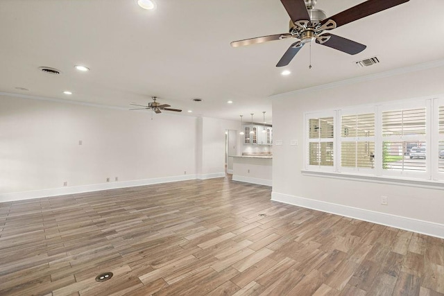 unfurnished living room with ornamental molding, ceiling fan, and hardwood / wood-style flooring