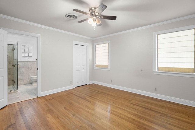 unfurnished bedroom featuring light hardwood / wood-style flooring, ensuite bath, ceiling fan, and crown molding