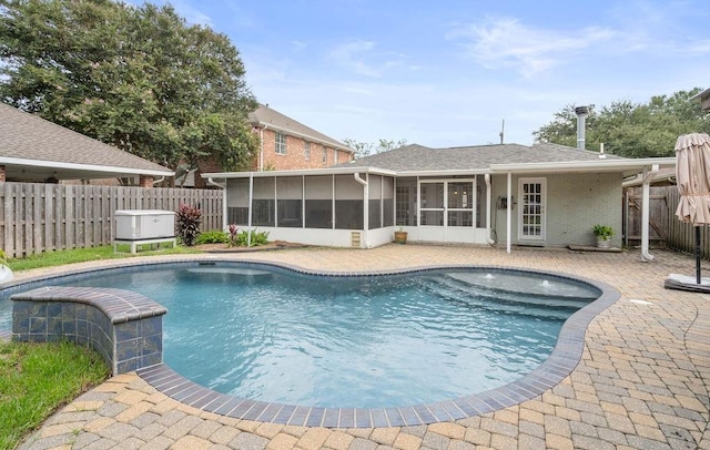 view of swimming pool with a sunroom and a patio area