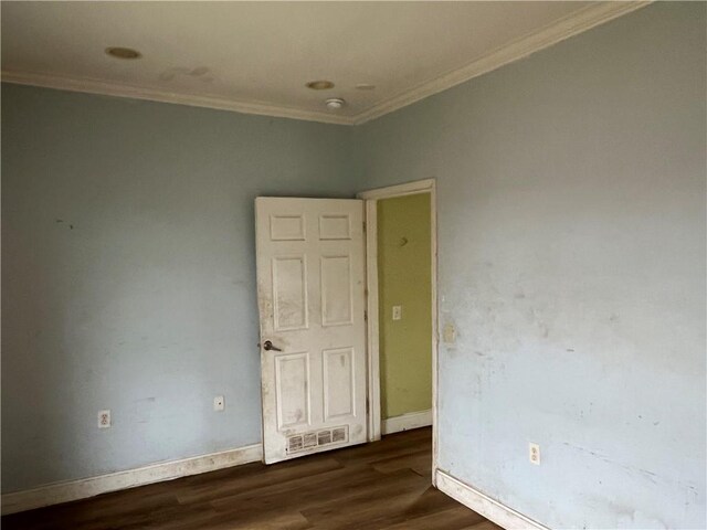 empty room featuring crown molding and dark wood-type flooring