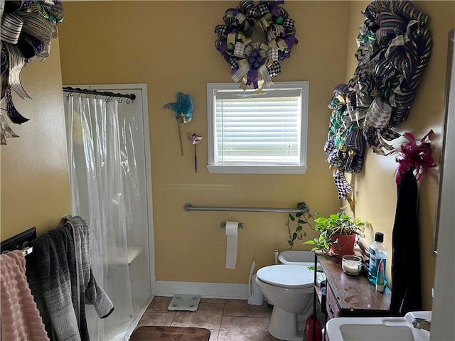 bathroom featuring toilet, tile patterned floors, and sink