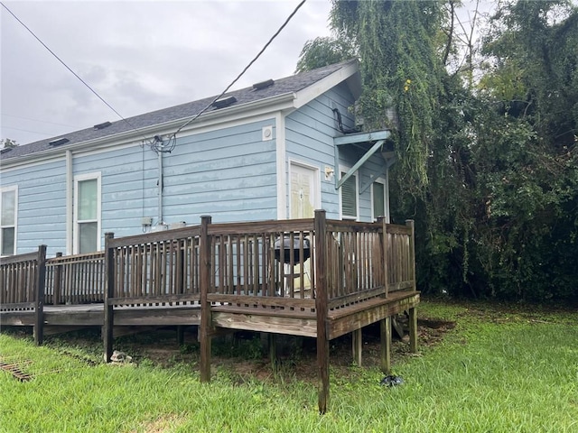 back of property featuring a lawn and a deck