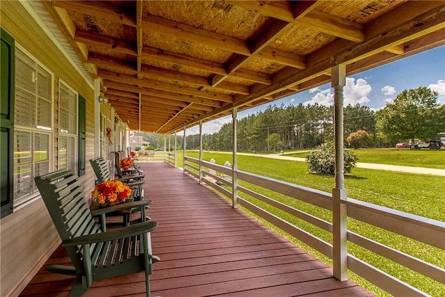 wooden terrace featuring a yard and covered porch