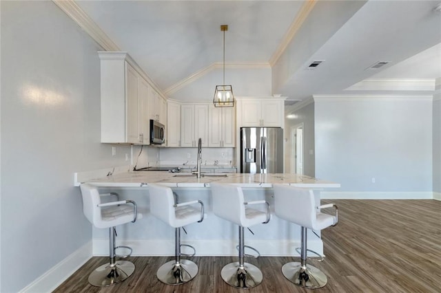 kitchen featuring white cabinets, hanging light fixtures, kitchen peninsula, dark wood-type flooring, and appliances with stainless steel finishes