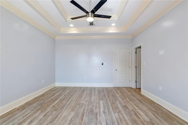 empty room featuring ornamental molding, a tray ceiling, ceiling fan, and light hardwood / wood-style flooring