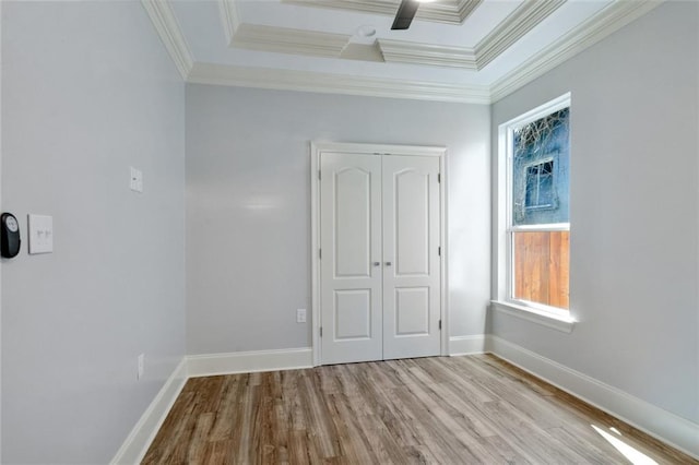 unfurnished bedroom featuring crown molding, ceiling fan, light hardwood / wood-style flooring, and a closet