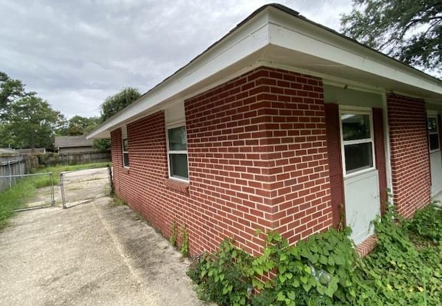 103 W Hickory St, Mandeville, LA 70471 - view of property exterior featuring fence, a gate, and brick siding