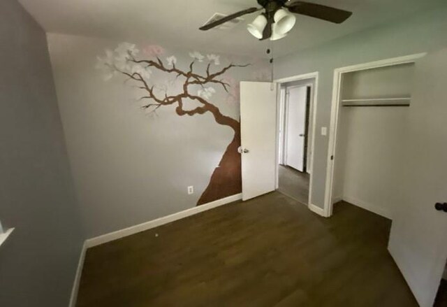 103 W Hickory St, Mandeville, LA 70471 - unfurnished bedroom featuring dark wood finished floors, baseboards, a ceiling fan, and a closet