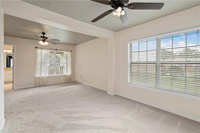 carpeted empty room featuring a wealth of natural light and ceiling fan