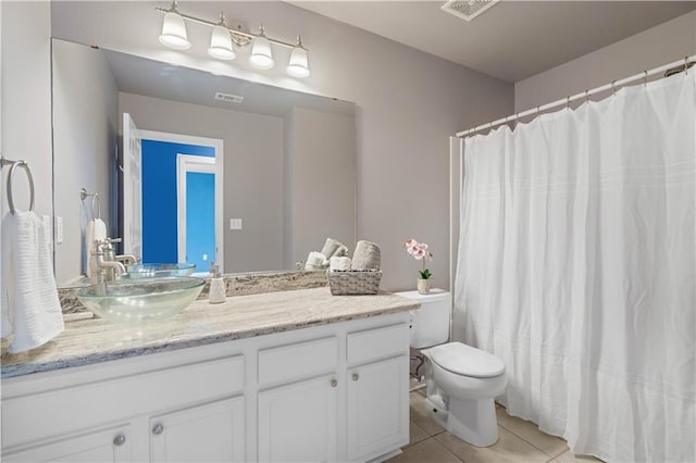 bathroom with curtained shower, vanity, toilet, and tile patterned floors