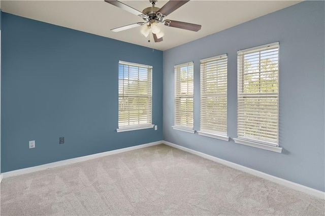 spare room with ceiling fan and light colored carpet