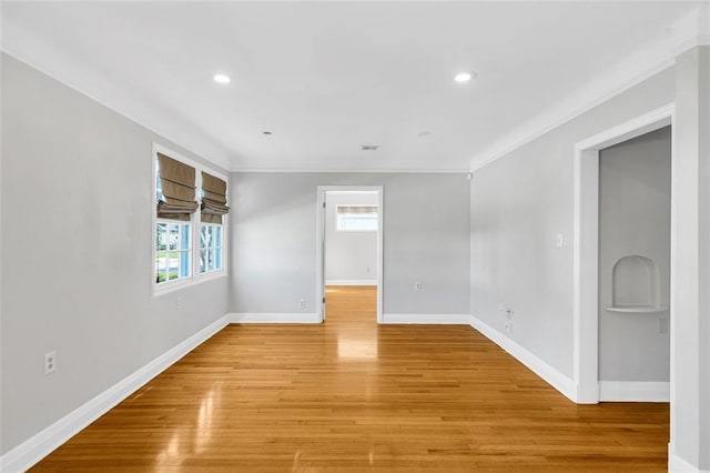 empty room featuring crown molding and light hardwood / wood-style flooring