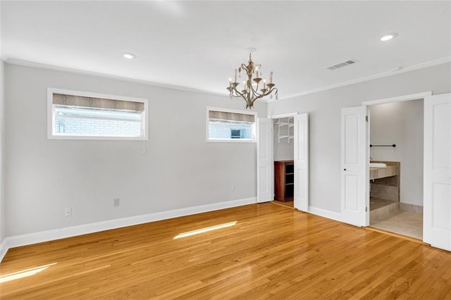 interior space featuring a notable chandelier, ornamental molding, and hardwood / wood-style flooring