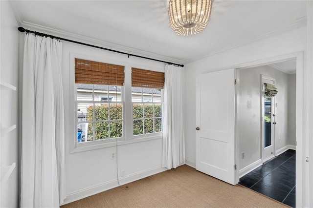 empty room featuring carpet, a chandelier, and crown molding