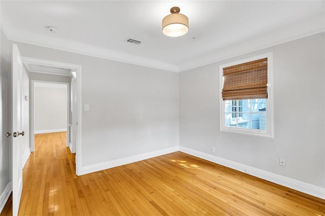 spare room featuring light hardwood / wood-style flooring and crown molding