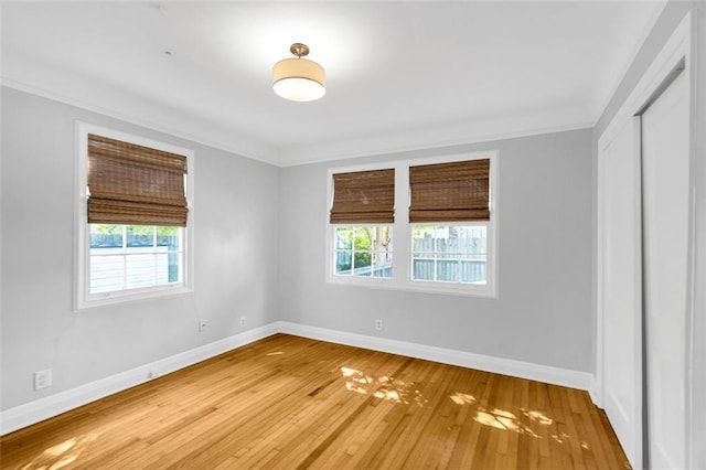 empty room with hardwood / wood-style flooring and ornamental molding