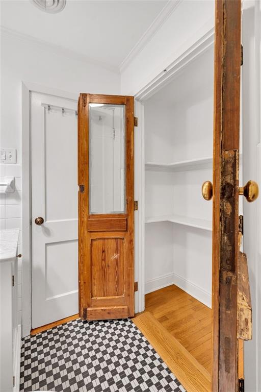 bathroom featuring wood-type flooring and crown molding