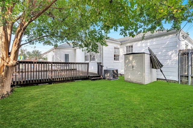 rear view of house with a wooden deck, a lawn, and central air condition unit