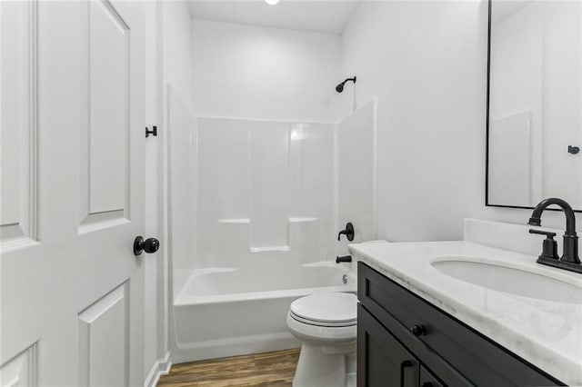 full bathroom featuring tub / shower combination, vanity, hardwood / wood-style floors, and toilet