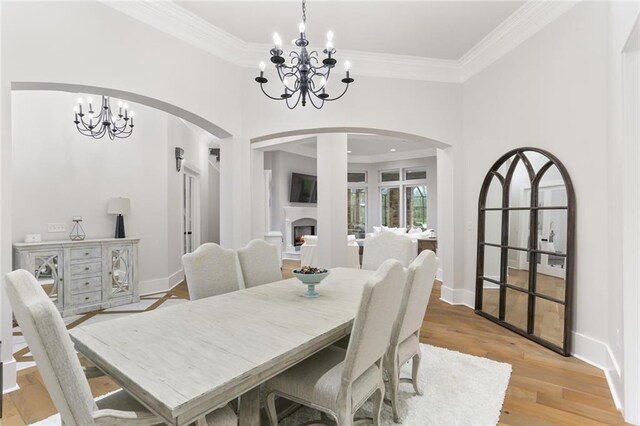 dining space with a chandelier, light hardwood / wood-style floors, and crown molding