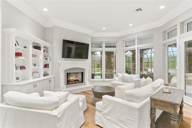 living room featuring ornamental molding, light hardwood / wood-style floors, and plenty of natural light