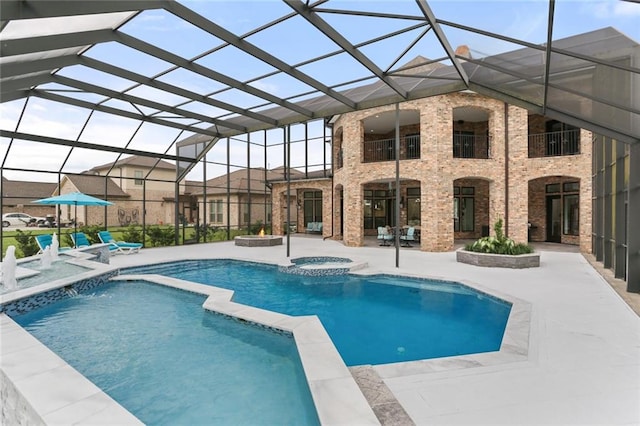 view of swimming pool with glass enclosure, an in ground hot tub, and a patio area