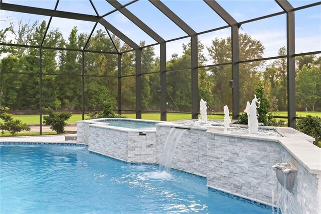 view of swimming pool with an in ground hot tub, a lanai, and pool water feature