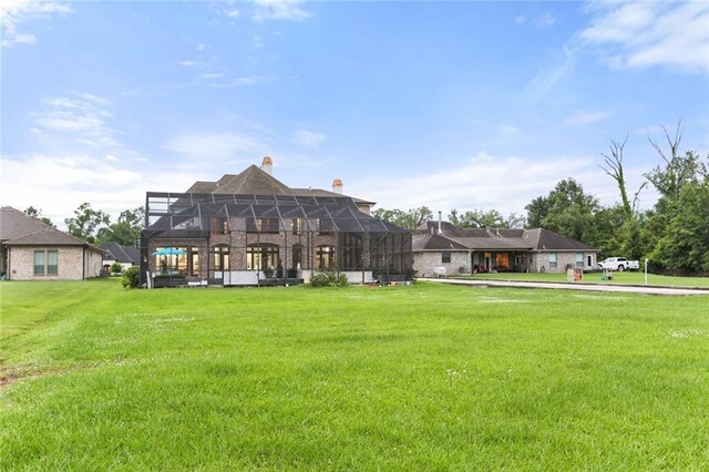 rear view of house featuring a swimming pool, a yard, and glass enclosure