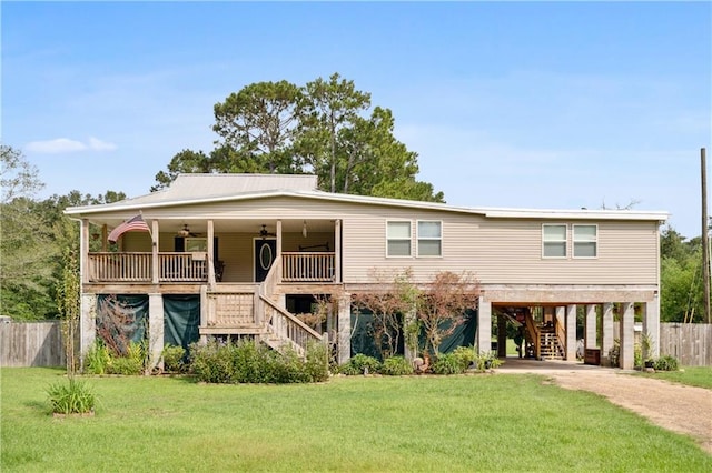 view of front of property featuring ceiling fan, a front lawn, and a carport