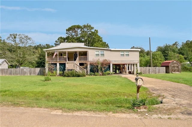 view of front of property with a storage shed, a front lawn, and a carport