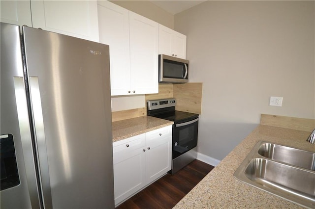 kitchen featuring light stone counters, sink, white cabinets, appliances with stainless steel finishes, and dark hardwood / wood-style flooring